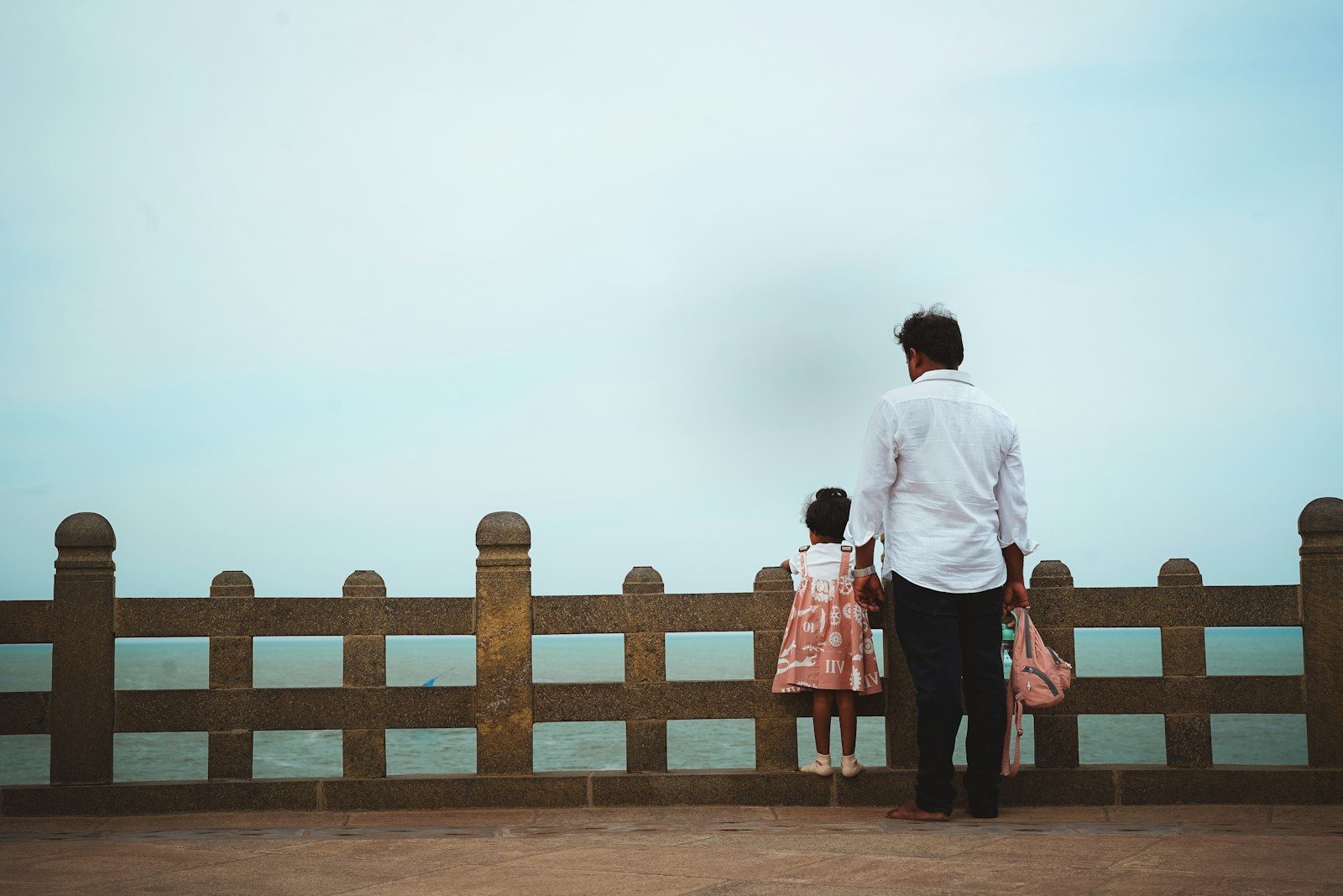 Man and child look out at the sea