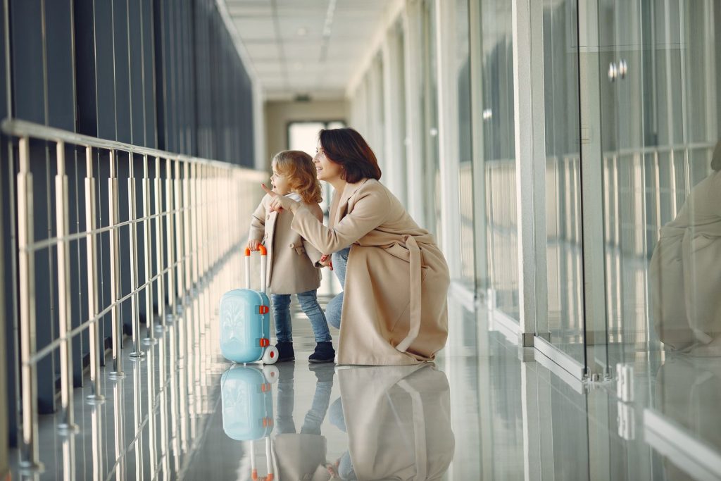 Mutter mit kleinem Kind und Koffer am Flughafen – Auslandsreise des Kindes ohne Zustimmung des anderen Elternteils