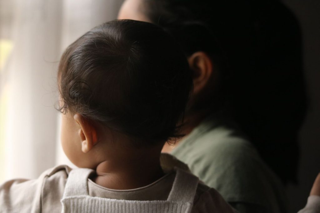 Mutter und Kind schauen gemeinsam aus dem Fenster – Fragen zum Sorge- und Umgangsrecht nach der Trennung