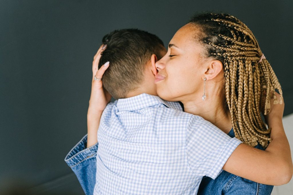 Mutter haelt ihr Kind schuetzend im Arm – Kinderschutz bei haeuslicher Gewalt