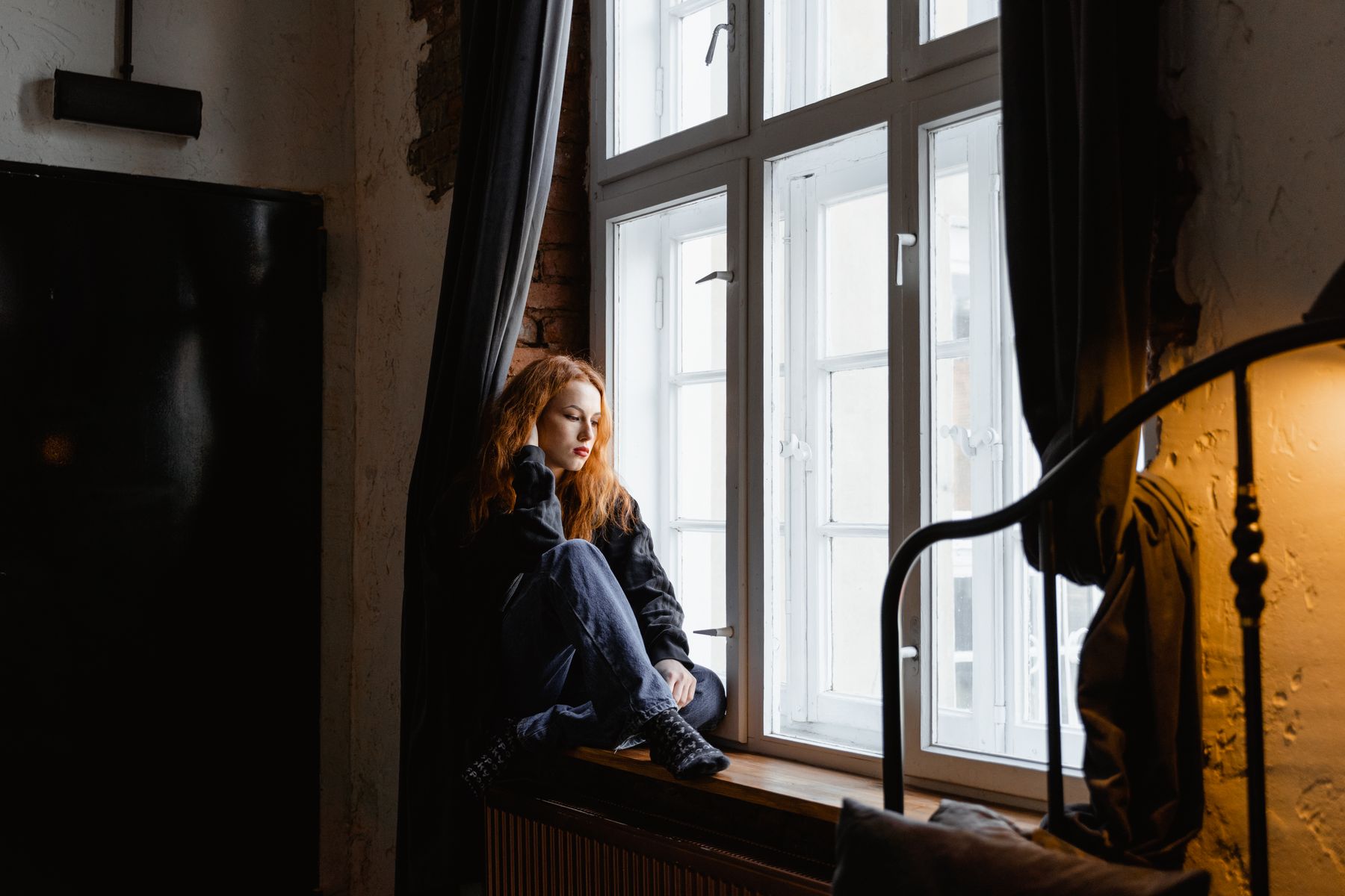 Nachdenkliche Frau am Fenster – Schutz vor häuslicher Gewalt nach dem Gewaltschutzgesetz